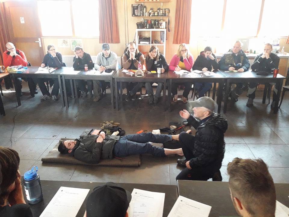 Demonstration of first aid, two people on the ground.